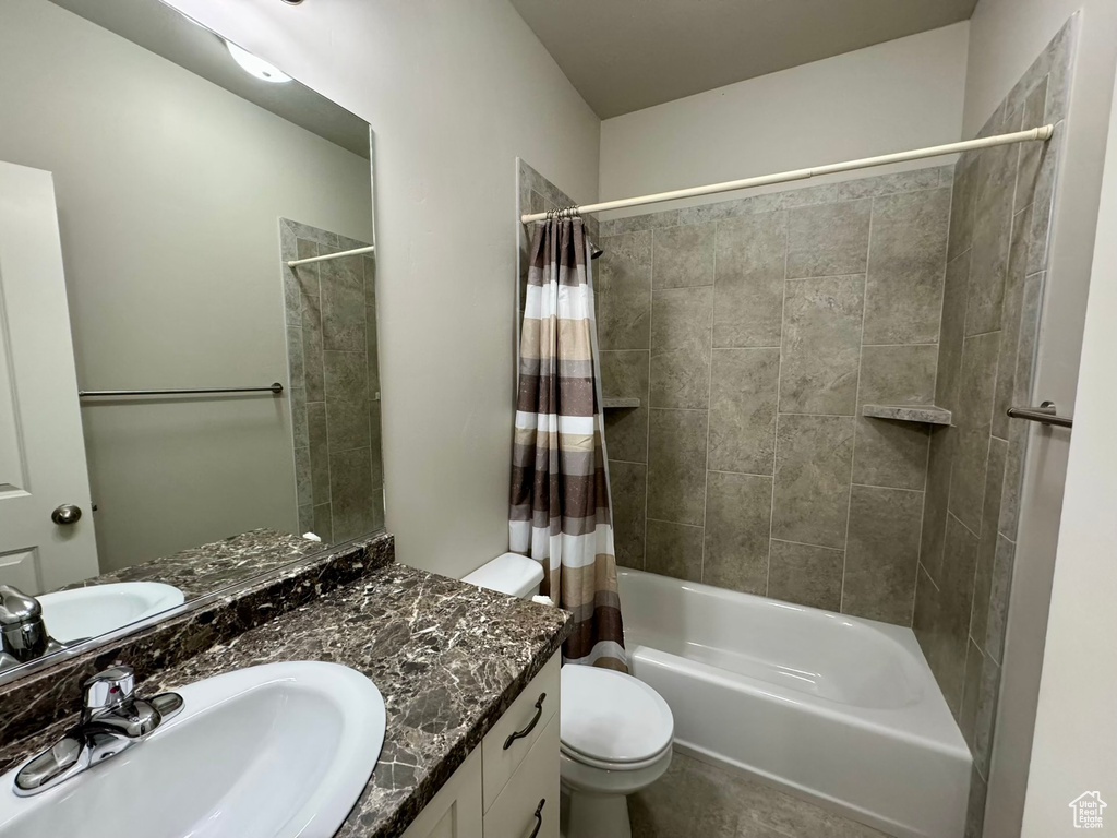 Full bathroom with oversized vanity, toilet, shower / bathtub combination with curtain, and tile flooring