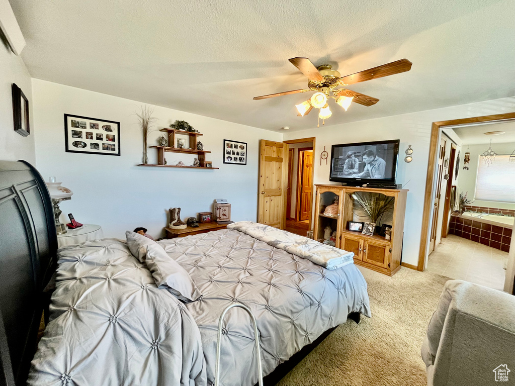Bedroom with a textured ceiling, ceiling fan, and light colored carpet