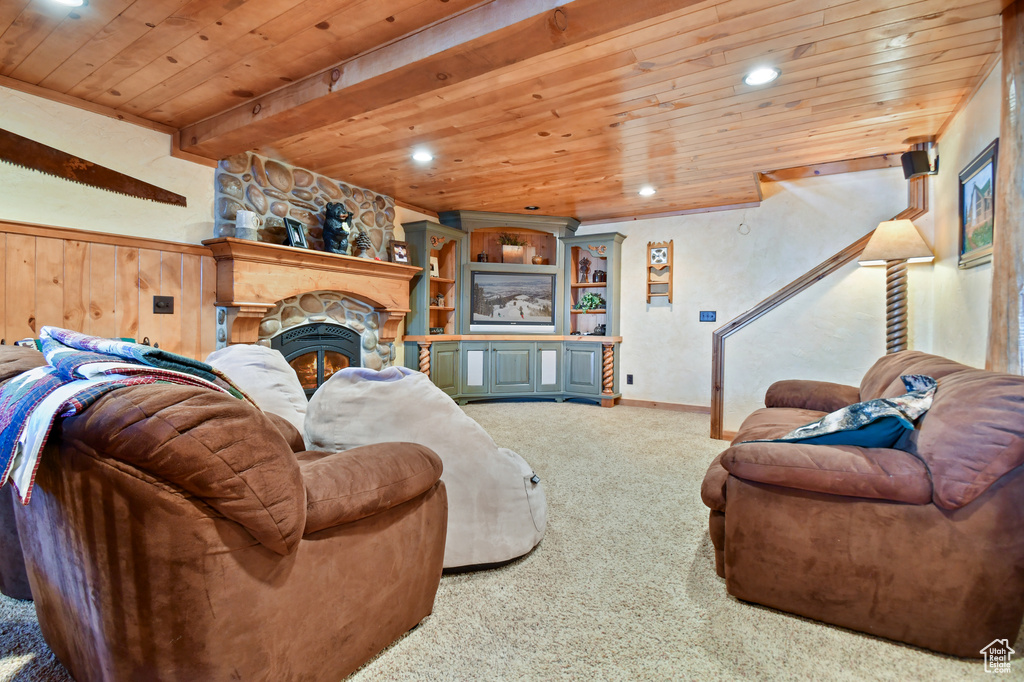 Carpeted living room with built in shelves, beam ceiling, wood ceiling, and a fireplace