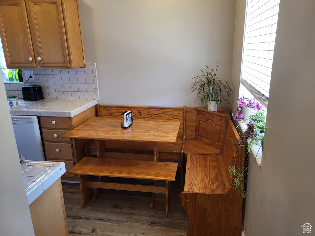 Kitchen featuring dark hardwood / wood-style flooring, backsplash, tile counters, and plenty of natural light