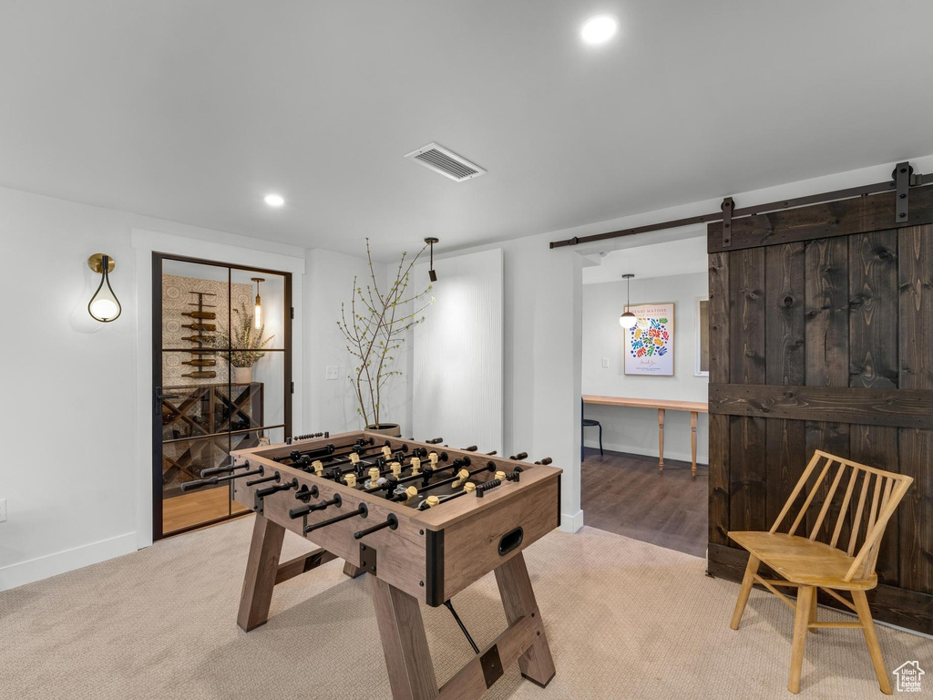 Game room featuring light carpet and a barn door