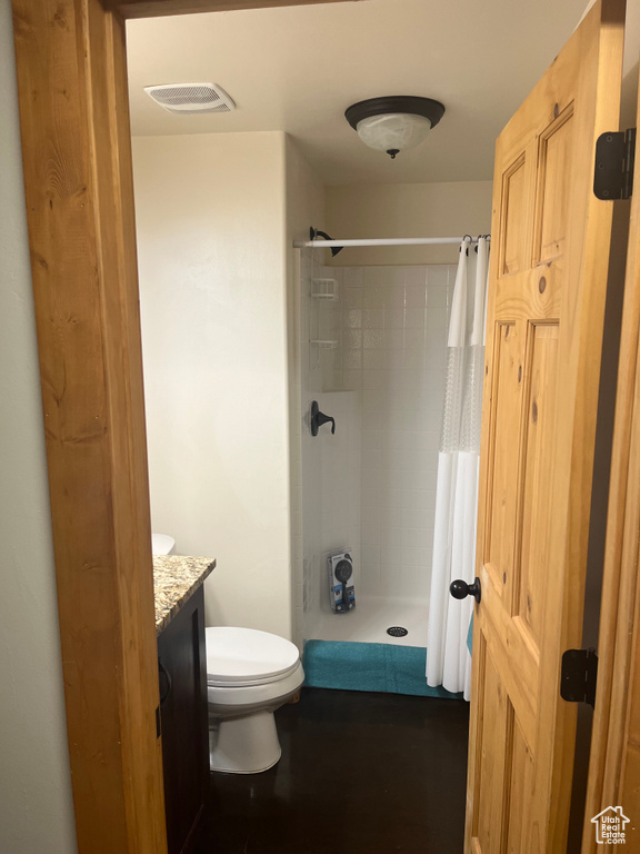 Bathroom with a shower with shower curtain, vanity, and toilet