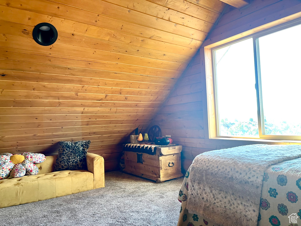Carpeted bedroom with wooden ceiling, wood walls, and vaulted ceiling