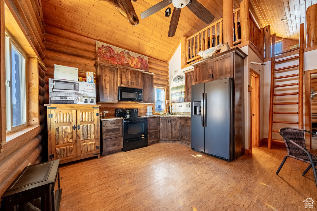 Kitchen with hardwood / wood-style floors, appliances with stainless steel finishes, and rustic walls