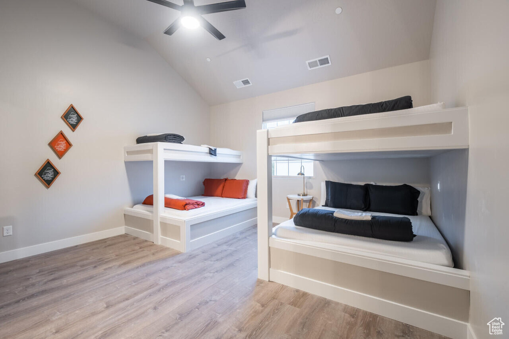 Bedroom with lofted ceiling, ceiling fan, and light wood-type flooring