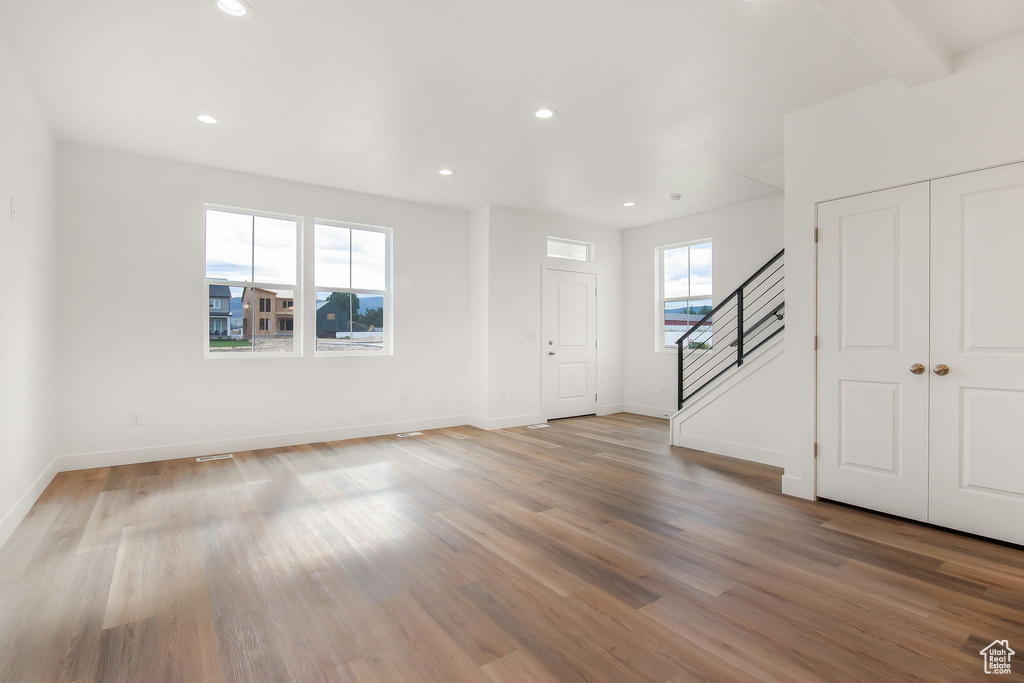 Unfurnished room featuring beam ceiling and hardwood / wood-style floors