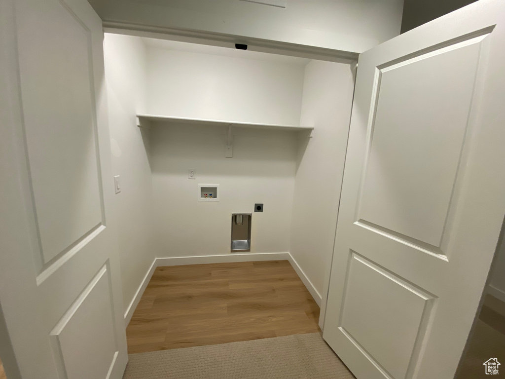 Washroom with hookup for an electric dryer, light hardwood / wood-style floors, and hookup for a washing machine
