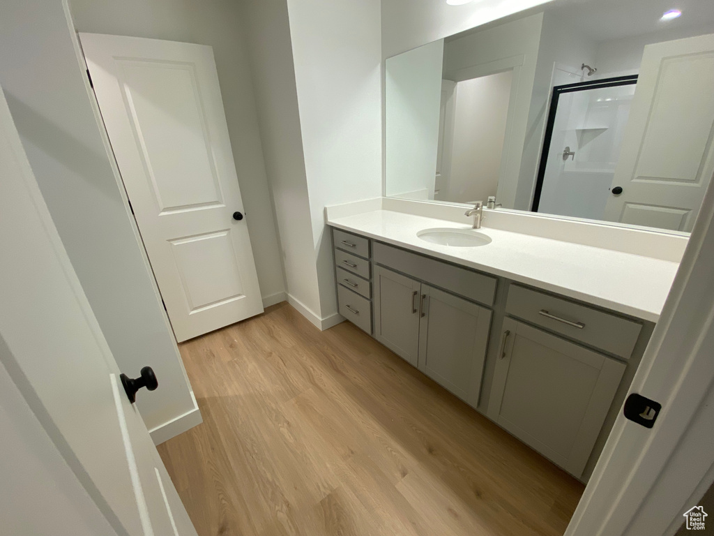 Bathroom featuring vanity, hardwood / wood-style floors, and an enclosed shower