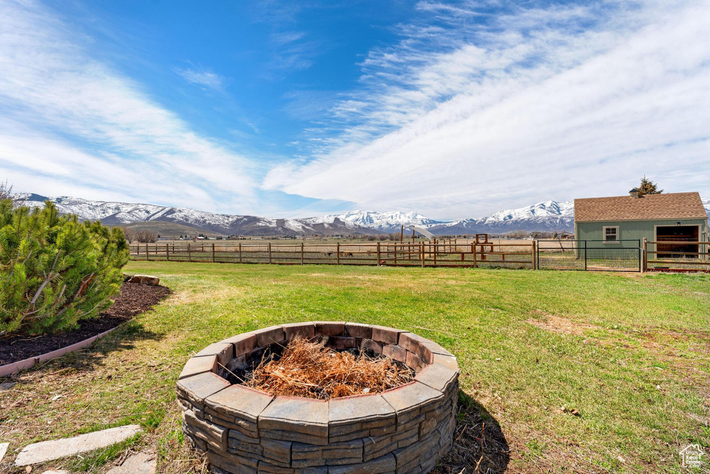 View of yard featuring a rural view, a fire pit, and a mountain view