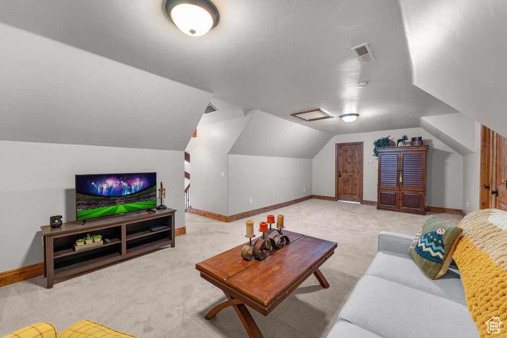 Carpeted living room featuring vaulted ceiling