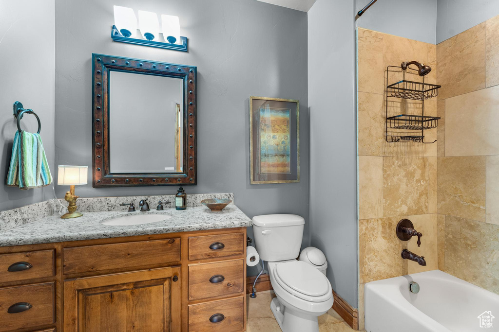 Full bathroom featuring tile floors, tiled shower / bath combo, toilet, and vanity