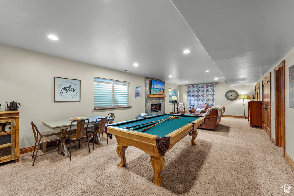 Recreation room featuring light carpet, billiards, and a stone fireplace