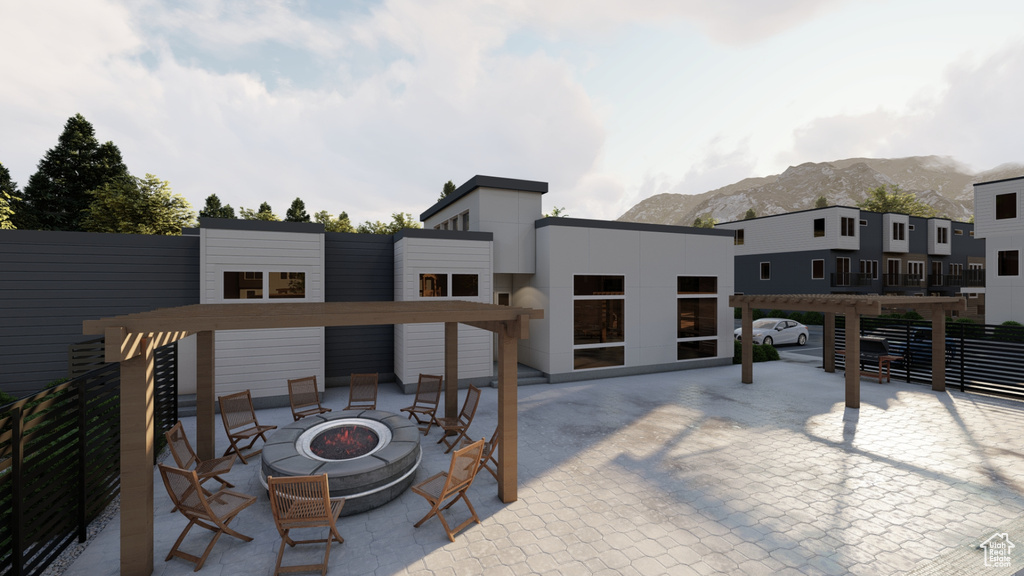 Back of house featuring a fire pit, a mountain view, and a patio area