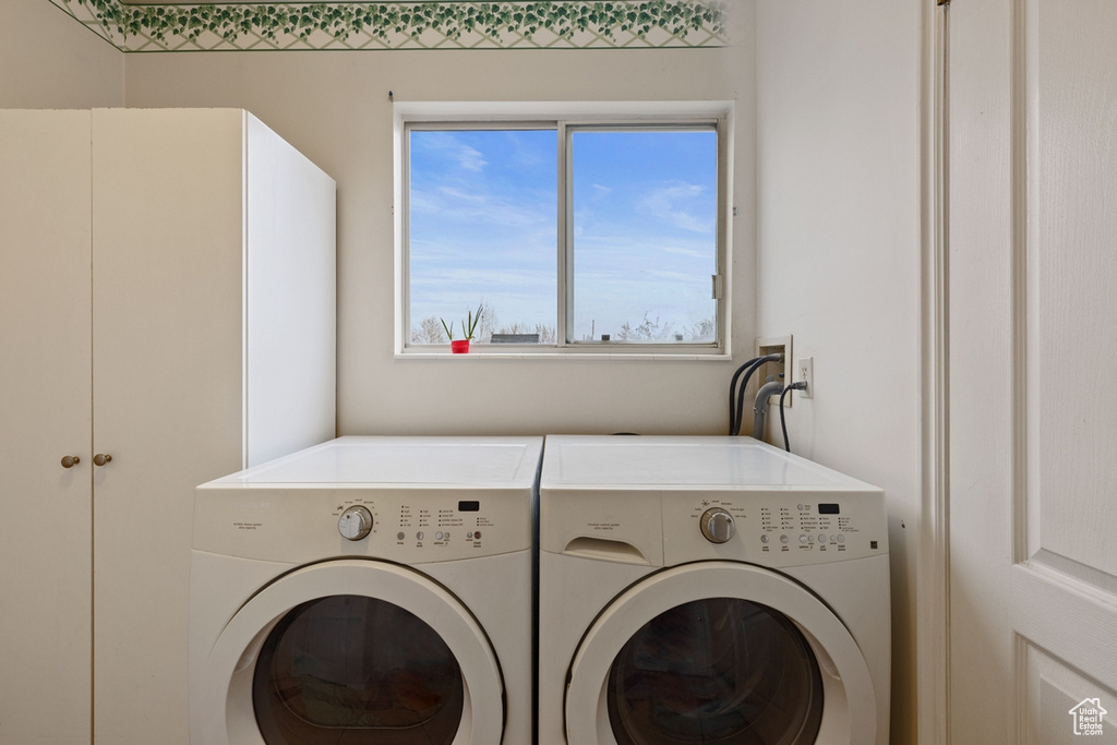 Clothes washing area featuring separate washer and dryer and hookup for a washing machine