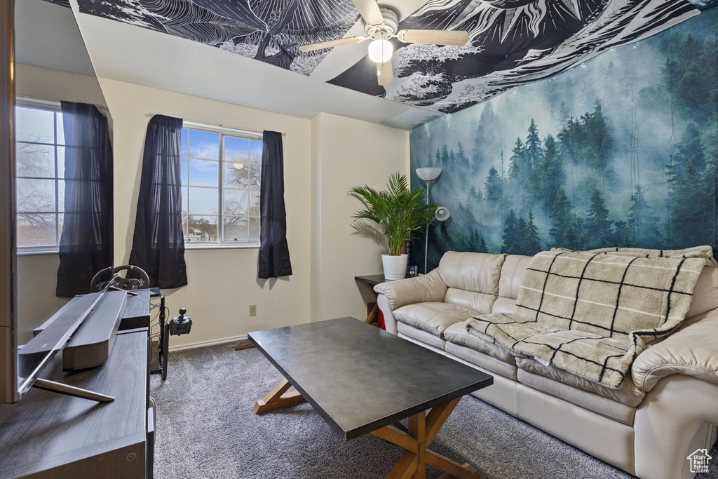Living room featuring ceiling fan and dark colored carpet