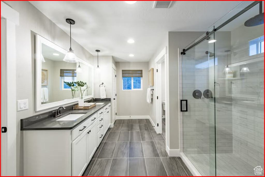 Bathroom featuring walk in shower, tile floors, and dual bowl vanity