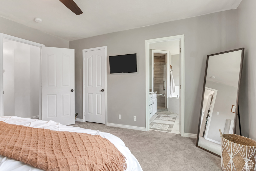 Carpeted bedroom with ceiling fan, a closet, and connected bathroom