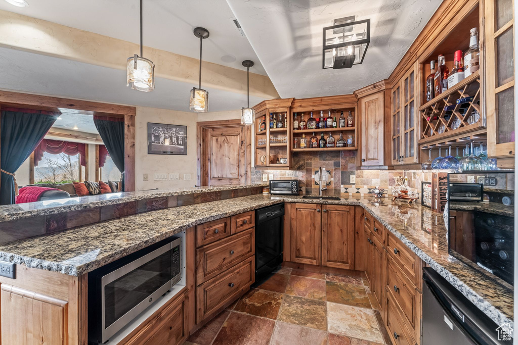 Kitchen featuring backsplash, pendant lighting, light stone countertops, dishwasher, and stainless steel microwave