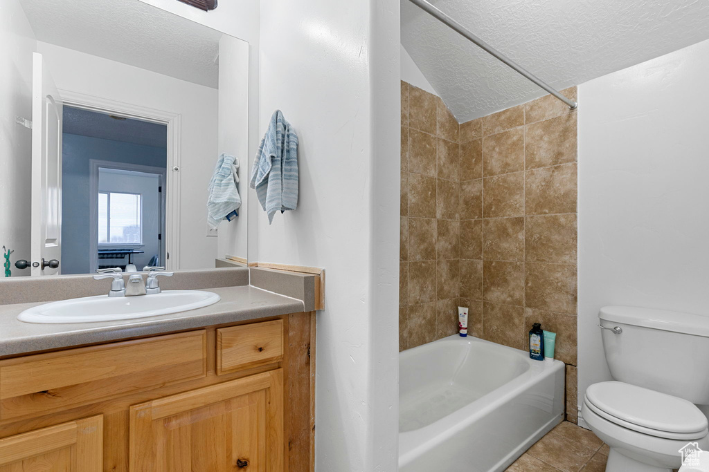 Full bathroom with toilet, tile floors, a textured ceiling, and vanity