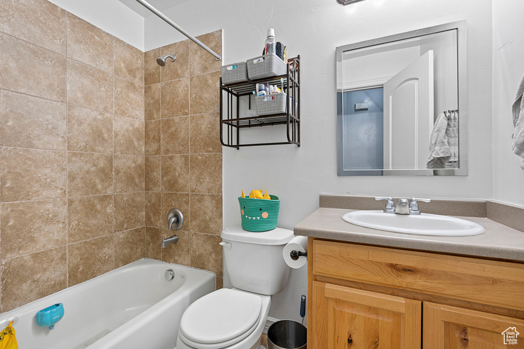Full bathroom with toilet, tiled shower / bath combo, and oversized vanity