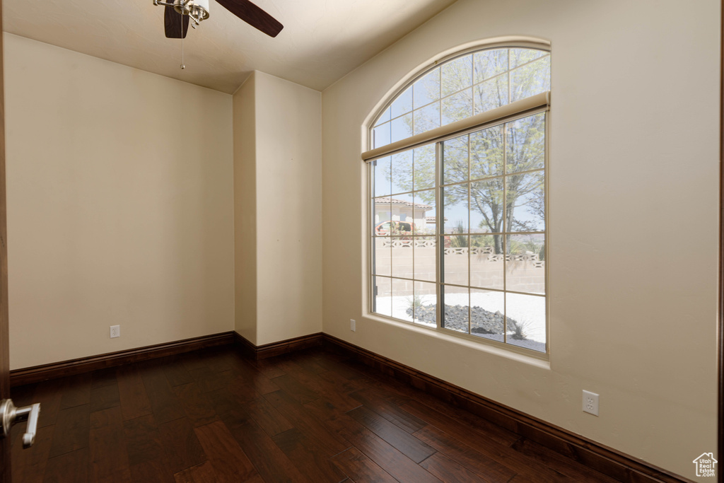 Spare room with plenty of natural light, ceiling fan, and dark wood-type flooring