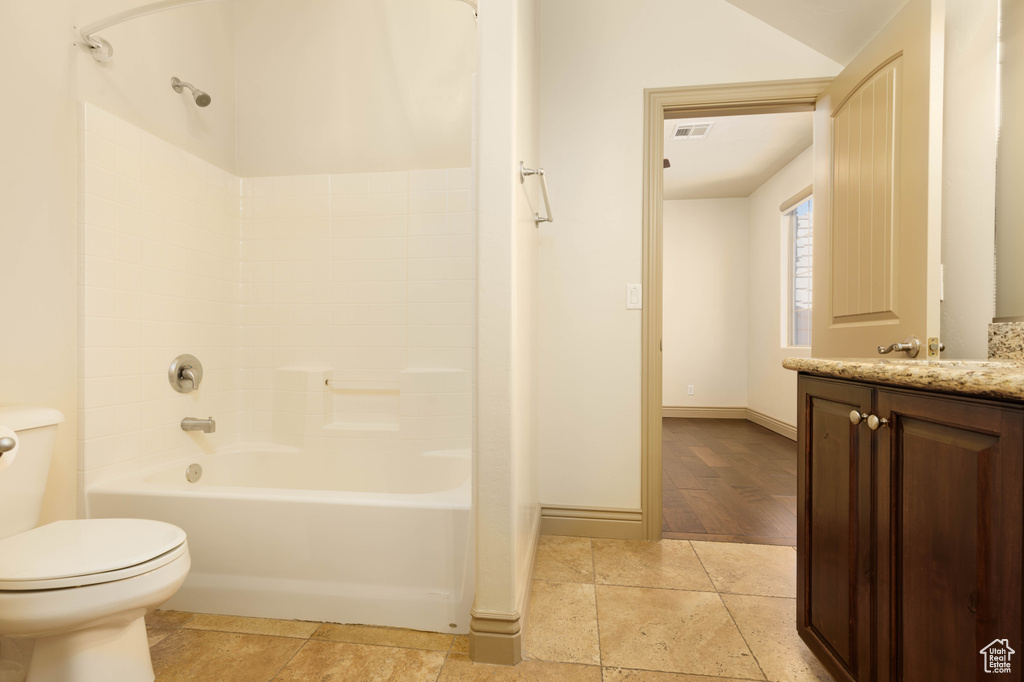 Full bathroom featuring hardwood / wood-style floors, toilet, shower / tub combination, and vanity