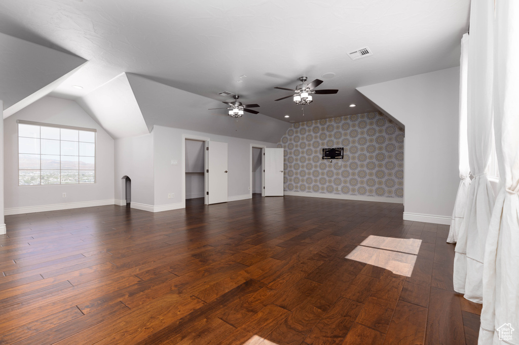 Bonus room featuring dark hardwood / wood-style flooring, ceiling fan, and lofted ceiling