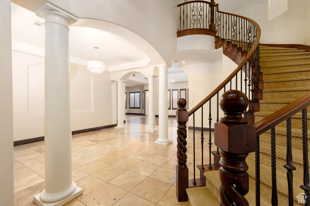 Tiled foyer entrance featuring a towering ceiling and ornate columns