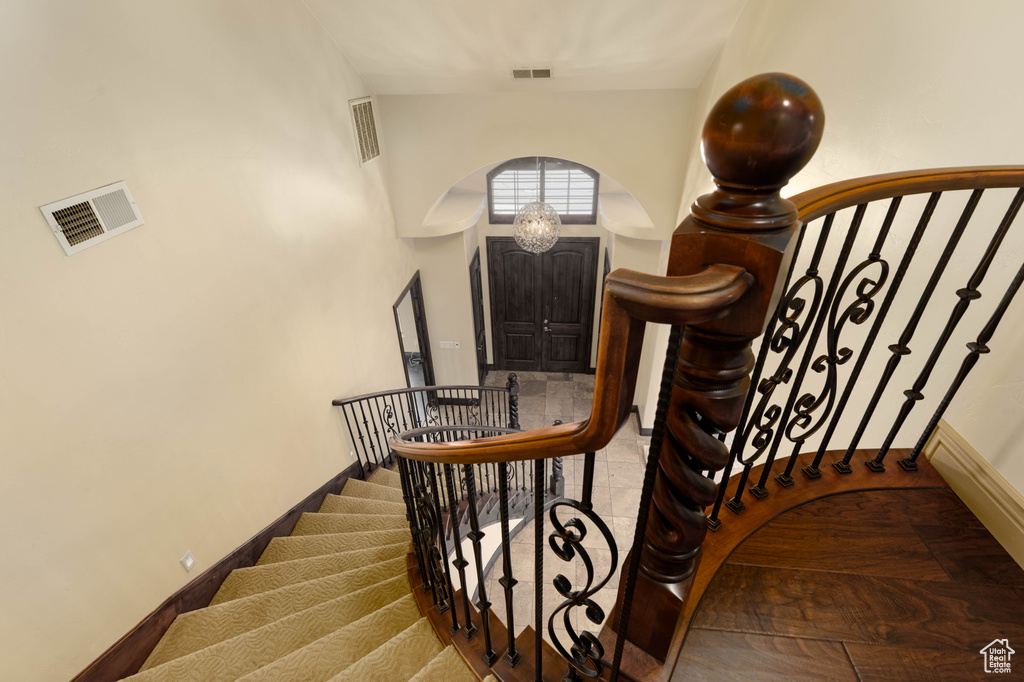 Stairway with a notable chandelier and light hardwood / wood-style flooring