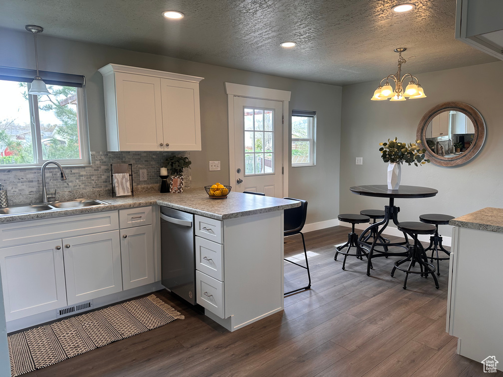 Kitchen featuring dark hardwood / wood-style flooring, dishwasher, white cabinetry, and sink