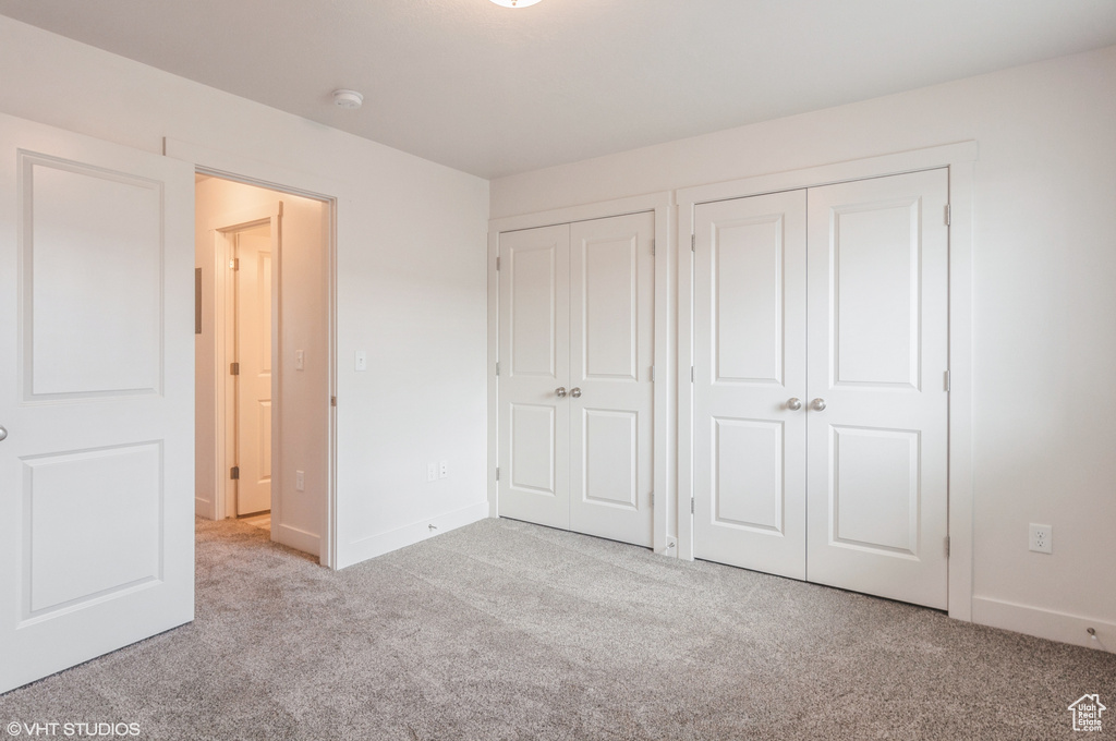 Unfurnished bedroom with light carpet and two closets