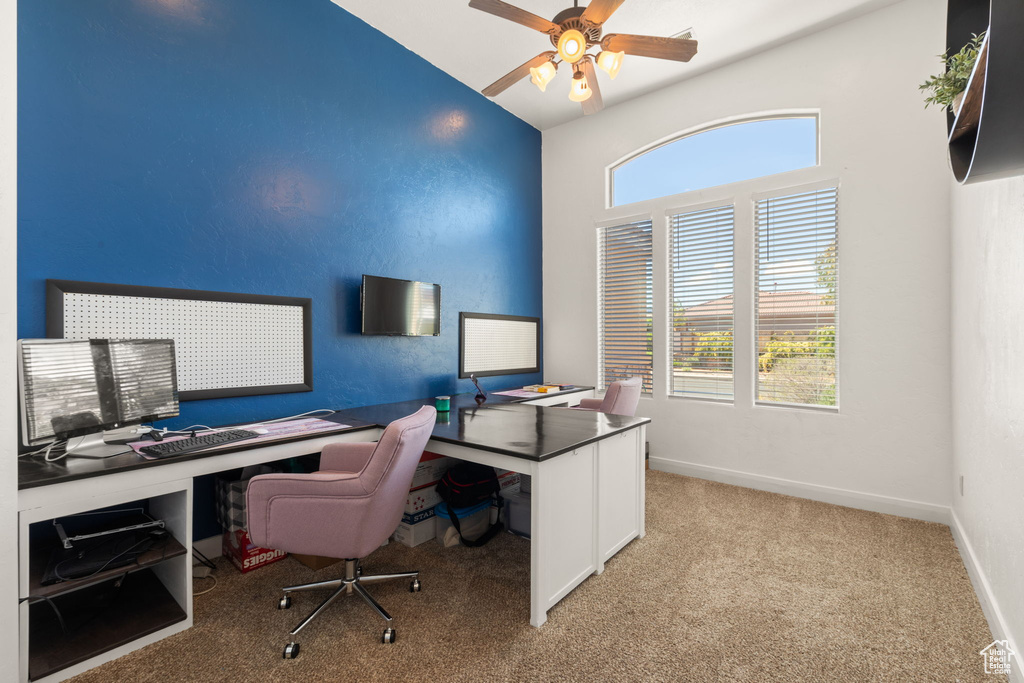 Home office with ceiling fan and light colored carpet