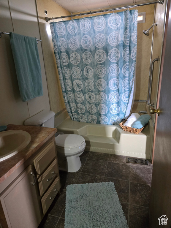 Full bathroom featuring tile flooring, toilet, shower / bath combo, and vanity
