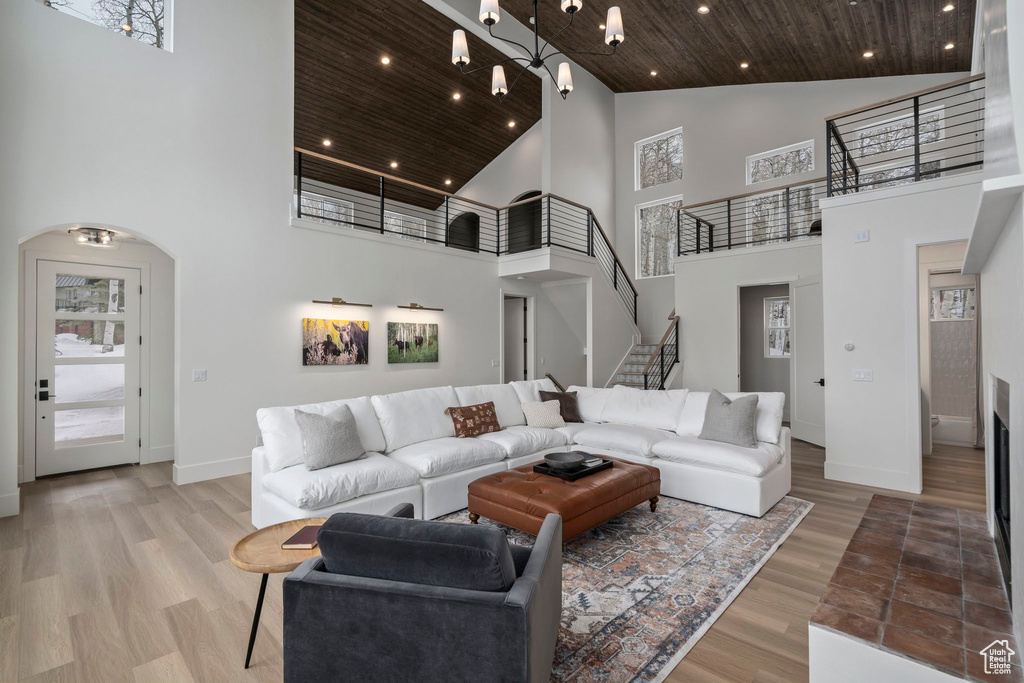 Living room with light hardwood / wood-style flooring, high vaulted ceiling, and wooden ceiling