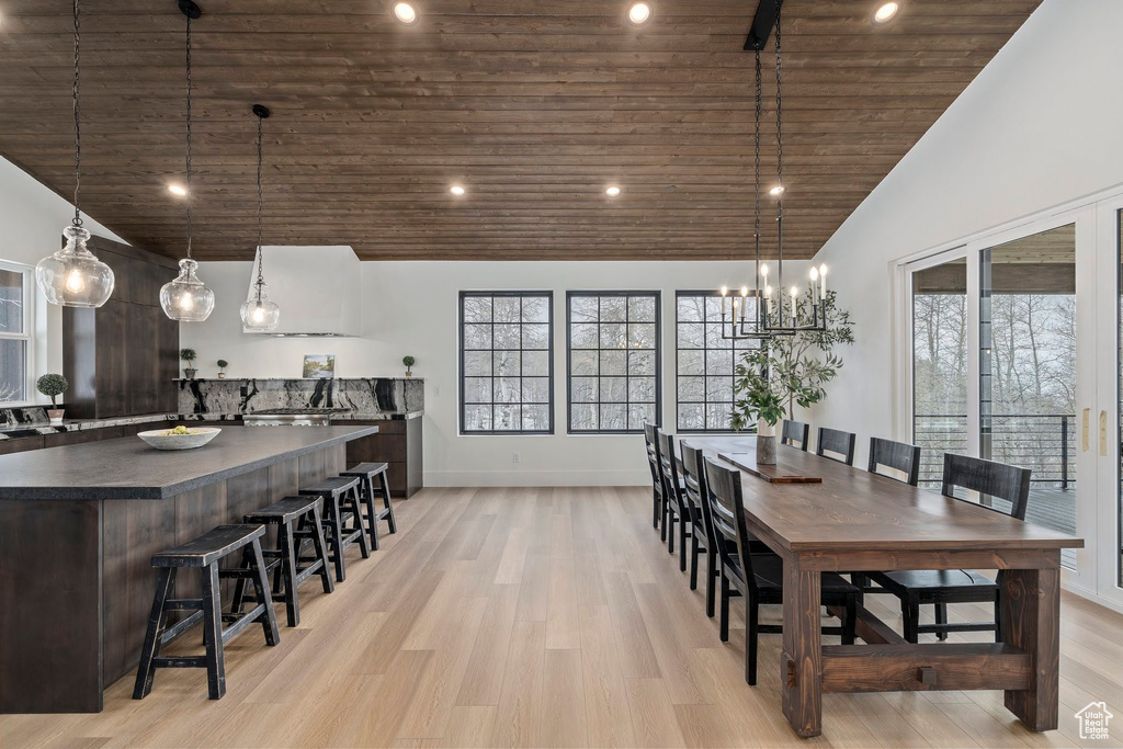 Dining area with high vaulted ceiling, wooden ceiling, and light wood-type flooring