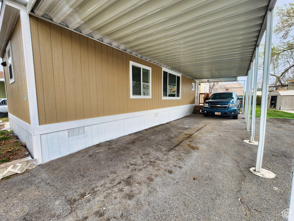 View of side of property with a storage shed and a carport