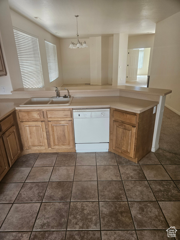 Kitchen featuring dark tile flooring, a chandelier, dishwasher, and sink