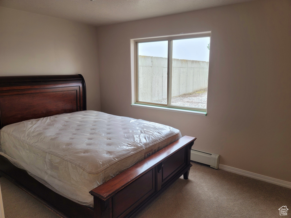 Bedroom featuring a baseboard radiator and carpet flooring