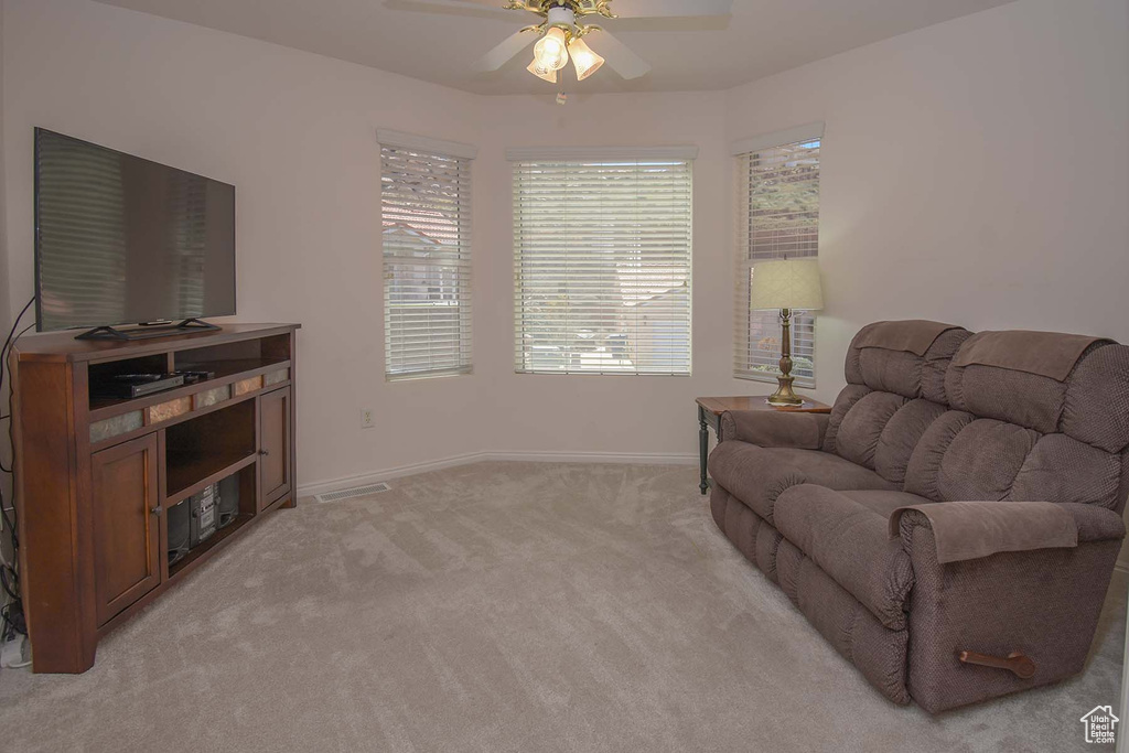 Living area featuring ceiling fan and light colored carpet