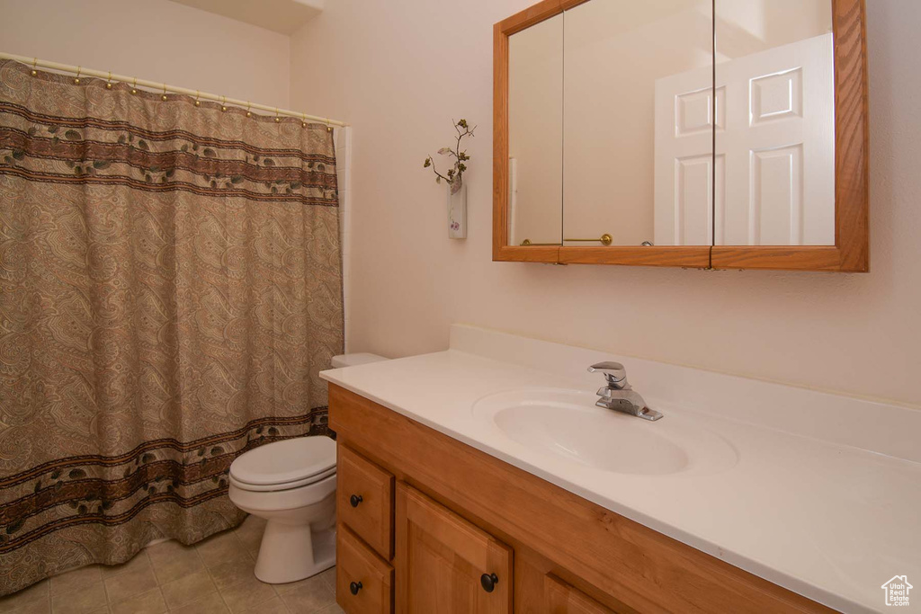 Bathroom with toilet, tile flooring, and oversized vanity