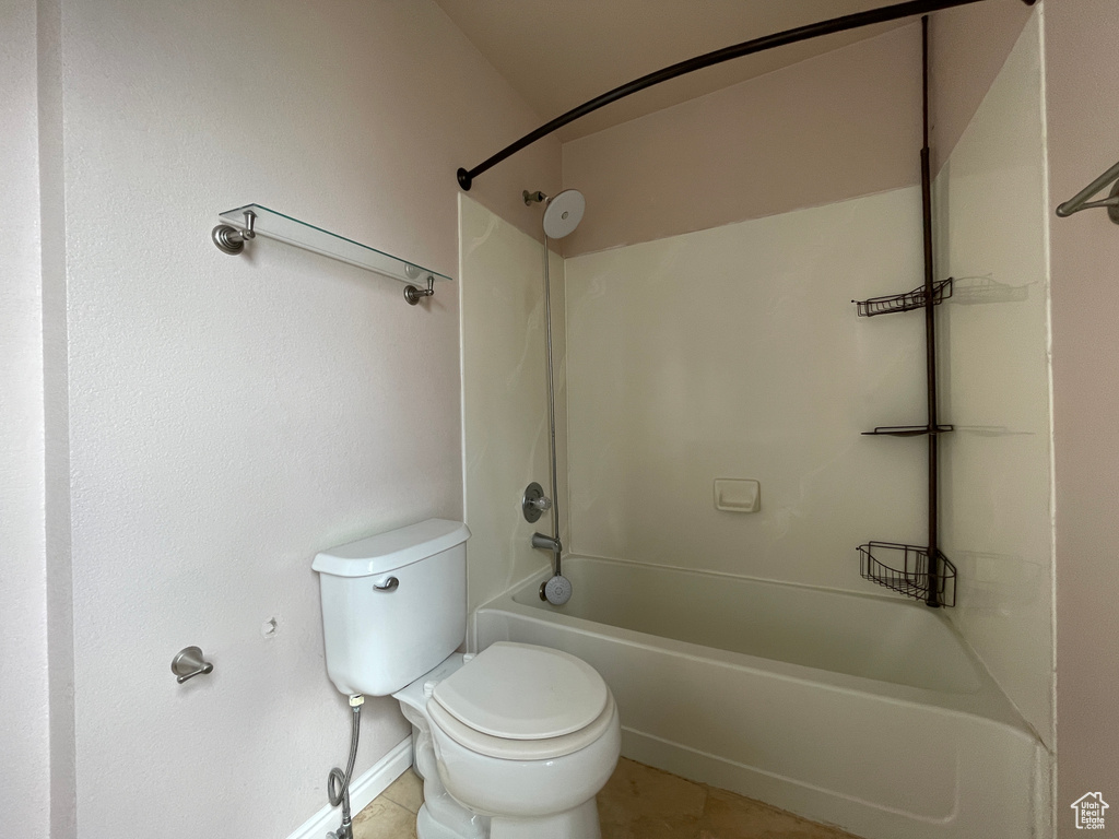 Bathroom featuring tub / shower combination, tile floors, and toilet