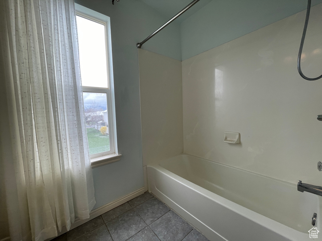 Bathroom featuring tile flooring, shower / bath combination with curtain, and a wealth of natural light