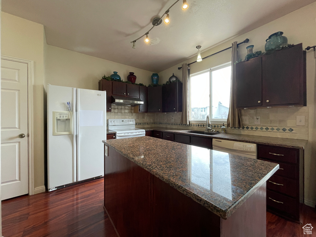 Kitchen with white appliances, dark wood-type flooring, and a center island