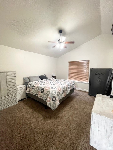 Bedroom with lofted ceiling, dark carpet, and ceiling fan