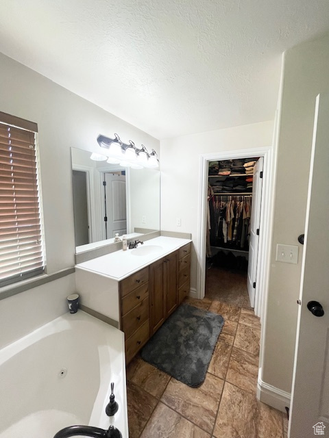 Bathroom featuring tile floors, a bathing tub, and vanity