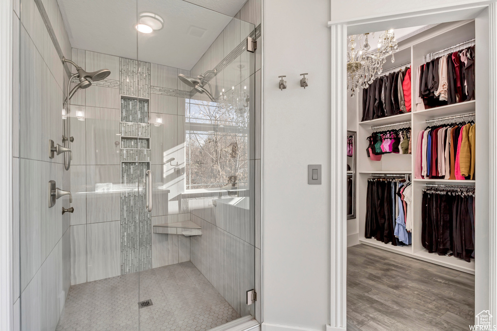Bathroom with a chandelier, walk in shower, and wood-type flooring