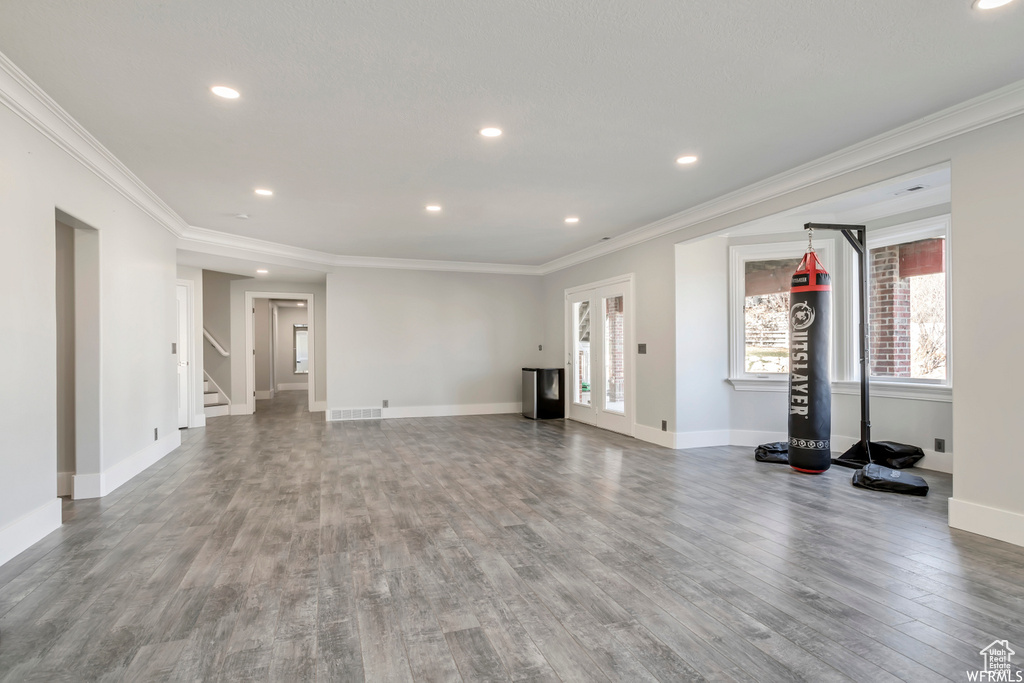 Workout room with wood-type flooring and ornamental molding