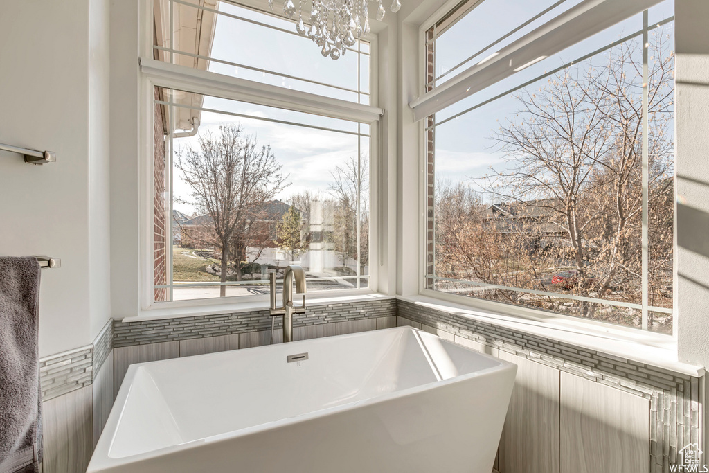 Bathroom featuring a washtub, sink, and an inviting chandelier