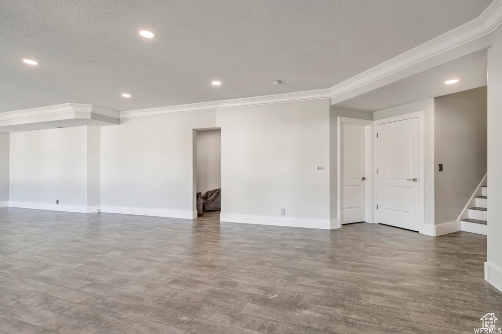 Unfurnished room featuring dark hardwood / wood-style flooring, crown molding, and a textured ceiling