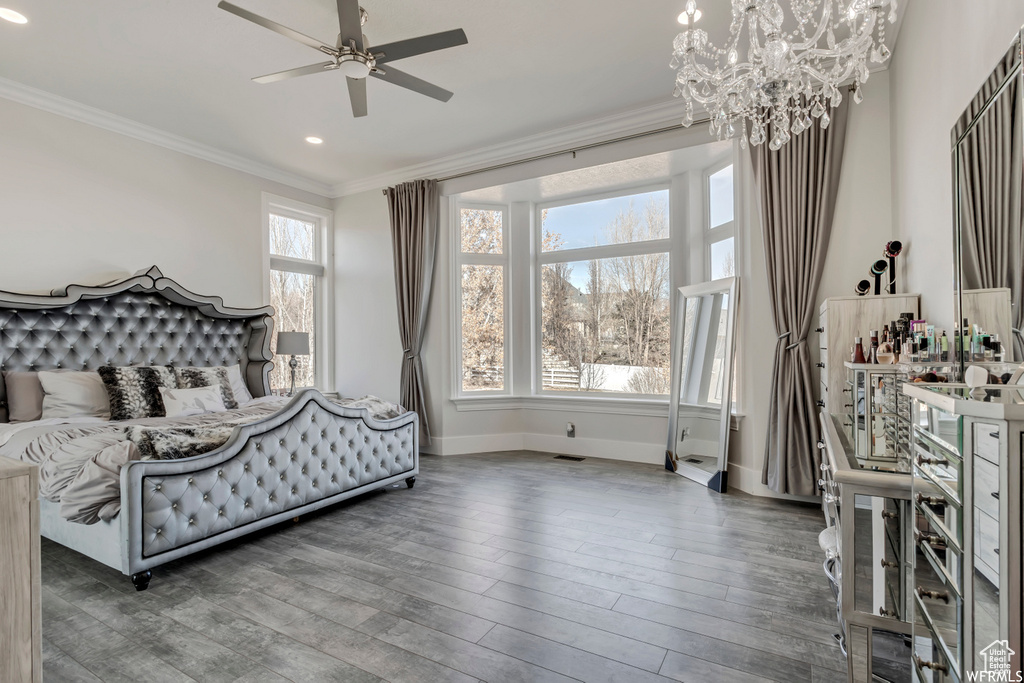 Bedroom featuring ceiling fan with notable chandelier, dark wood-type flooring, and ornamental molding